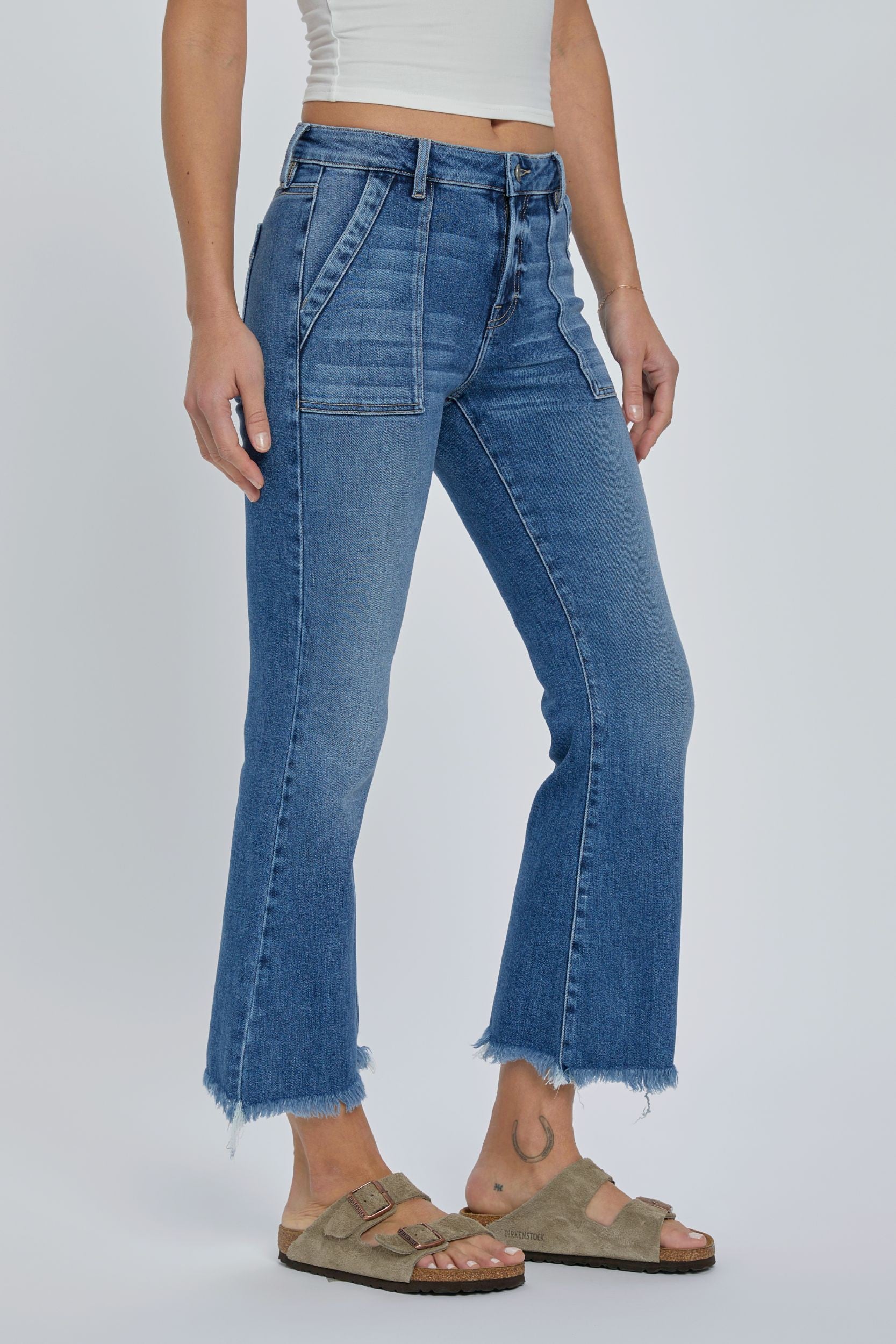 Hidden Inseam Happi Cargo Flare Medium Dark. These trendy flare jeans feature cargo front pockets and a frayed bottom hem in a comfortable stretch denim fabric that's perfect for everyday.