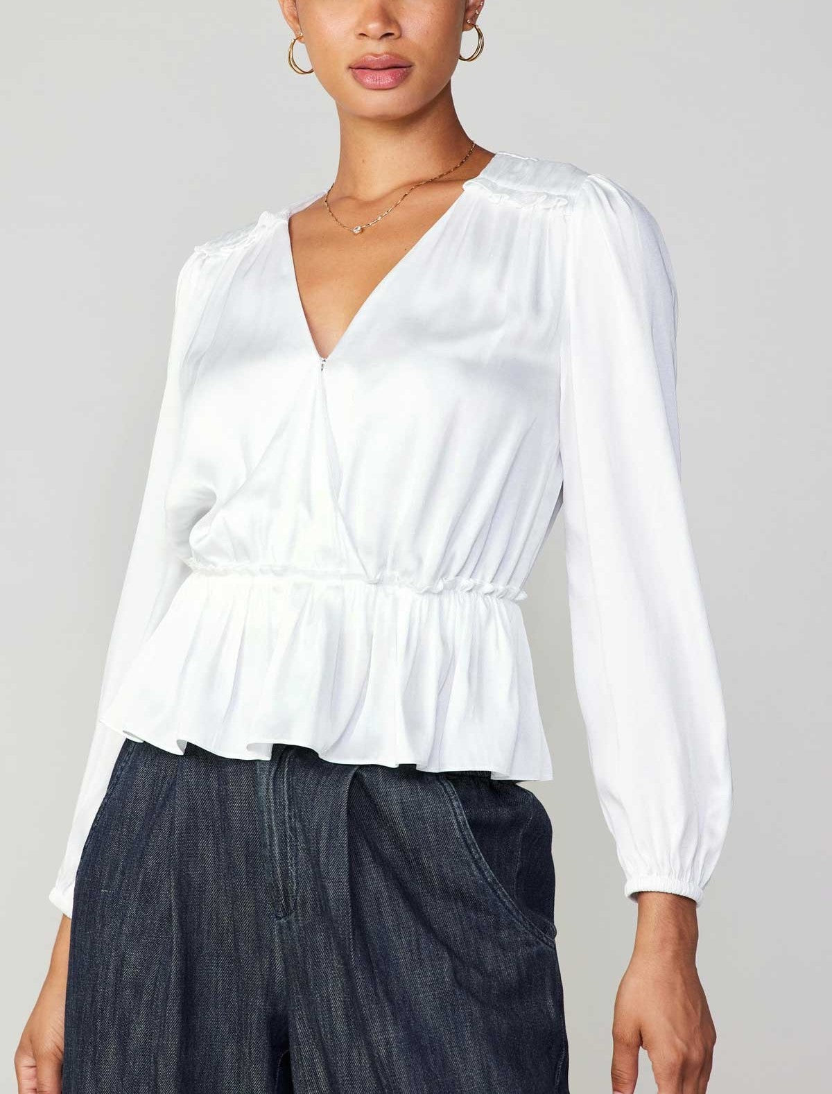 Current Air Peplum Surplus Blouse White. This long sleeve v-neck surplus blouse features a cinched waist with ruffle detail on the shoulder, the perfect everyday top to wear day or night.