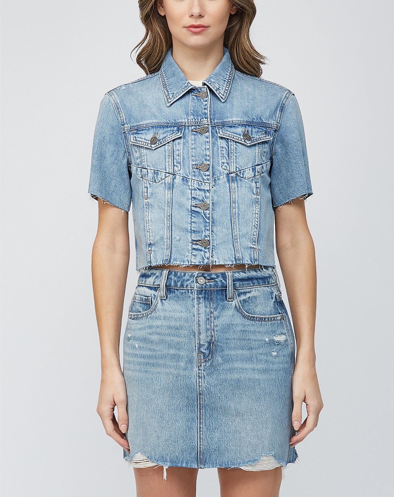 Hidden Short Sleeve Crop Jacket. This denim jacket features a cropped fit and short sleeve design with button closures and front patch pockets, wear it open as a layering piece or closed on its own.
