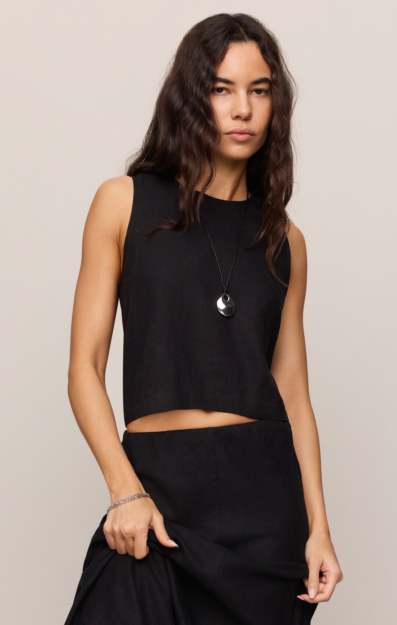 Sleeveless cropped high-neck top with a clean, minimalist silhouette and relaxed fit, shown styled with coordinating bottoms.