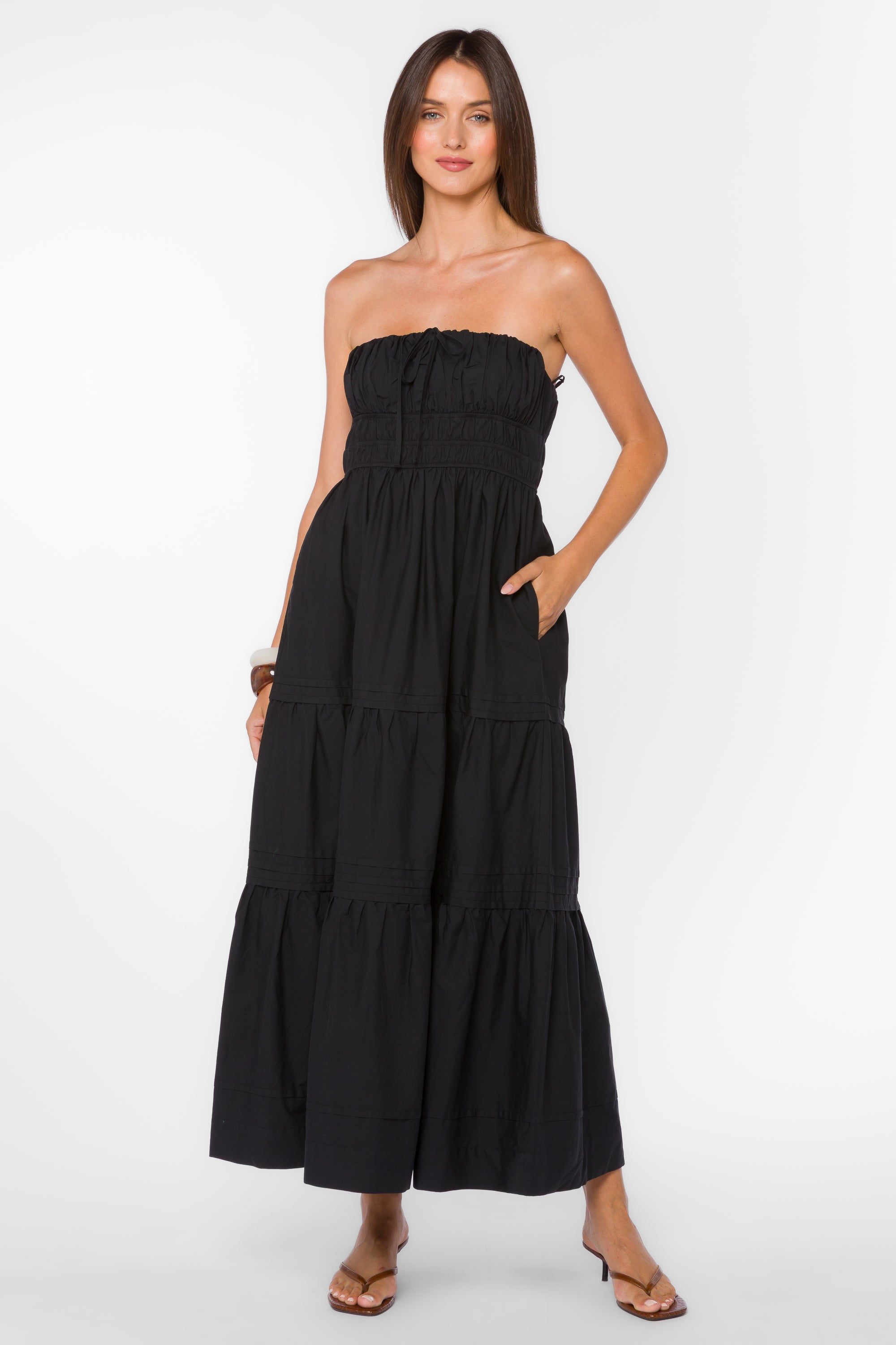 Strapless smocked midi dress with a tiered skirt and relaxed fit worn with flat sandals