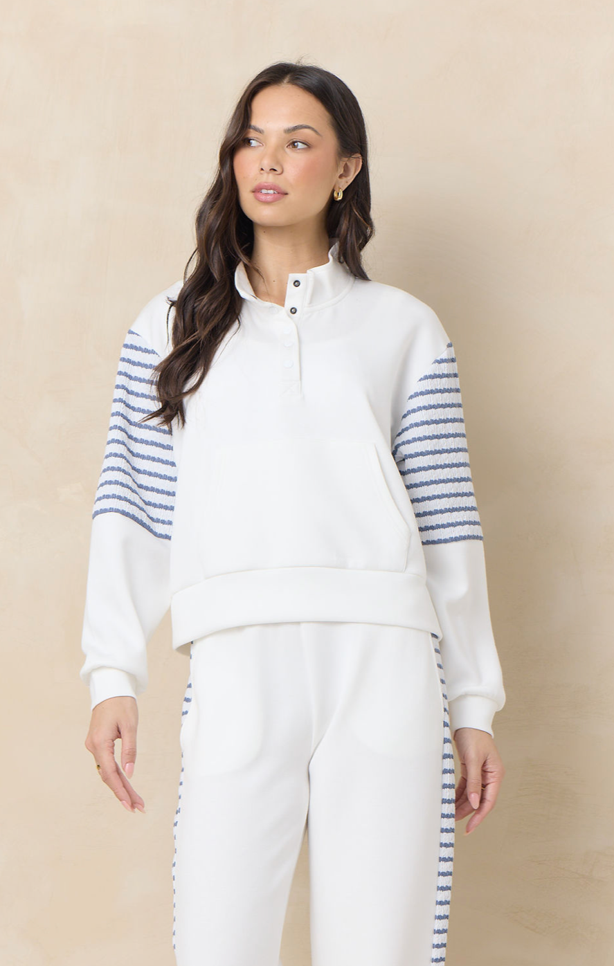 Matching ivory lounge set with striped sleeve and pant detailing featuring a relaxed pullover top and coordinating wide leg pants.