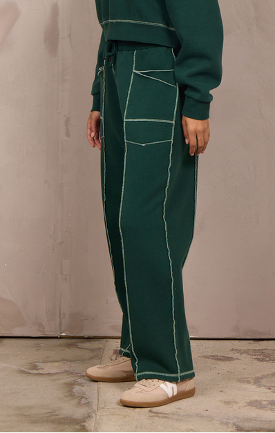 Woman wearing a wide-leg barbell pant with contrast stitching.