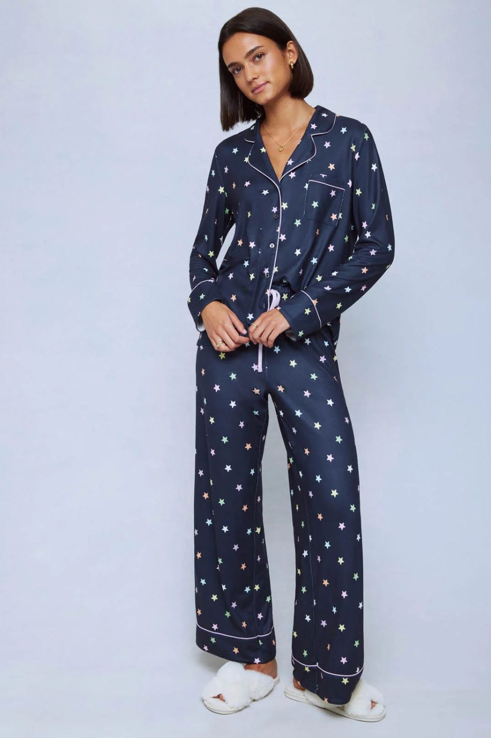 A cozy two-piece sleep set featuring brushed Pillowsoft fabric, a button-front top with contrast piping, and full-length drawstring pants for relaxing in comfort