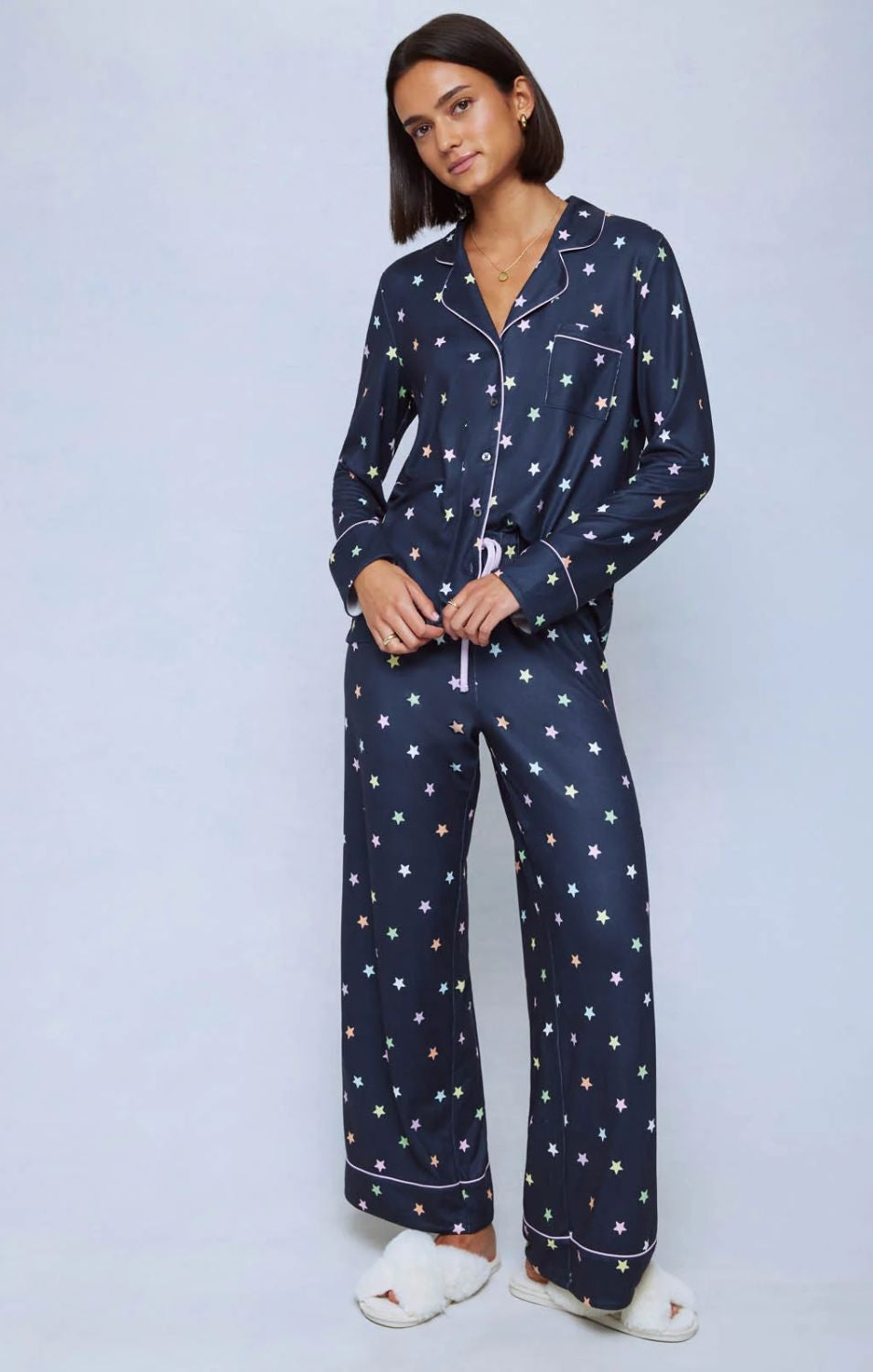 A cozy two-piece sleep set featuring brushed Pillowsoft fabric, a button-front top with contrast piping, and full-length drawstring pants for relaxing in comfort