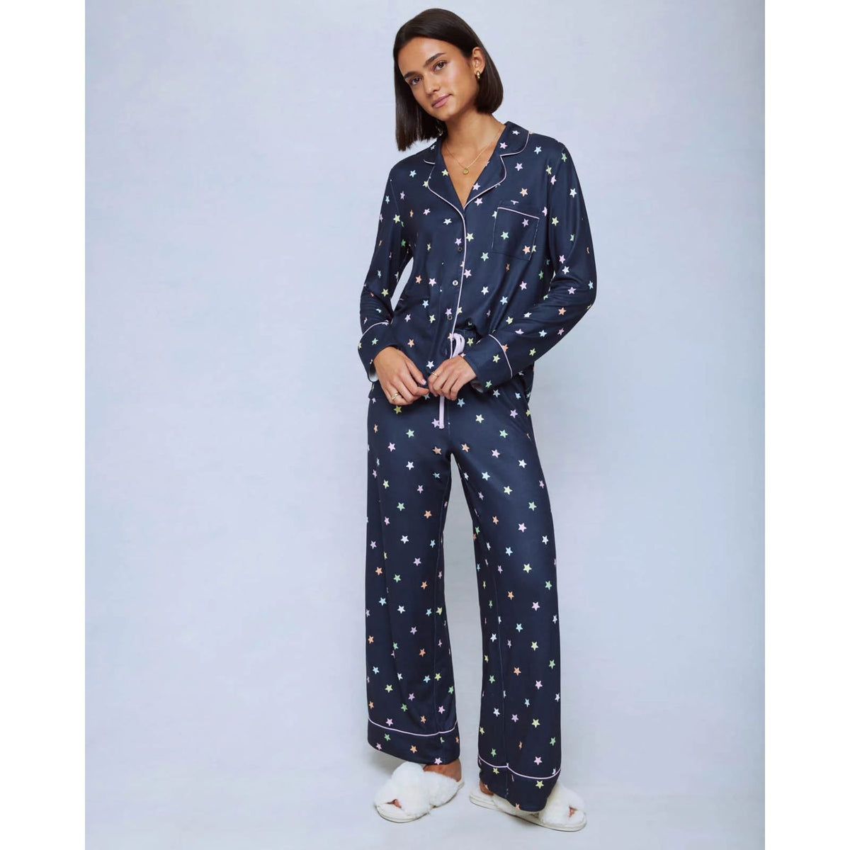 A cozy two-piece sleep set featuring brushed Pillowsoft fabric, a button-front top with contrast piping, and full-length drawstring pants for relaxing in comfort