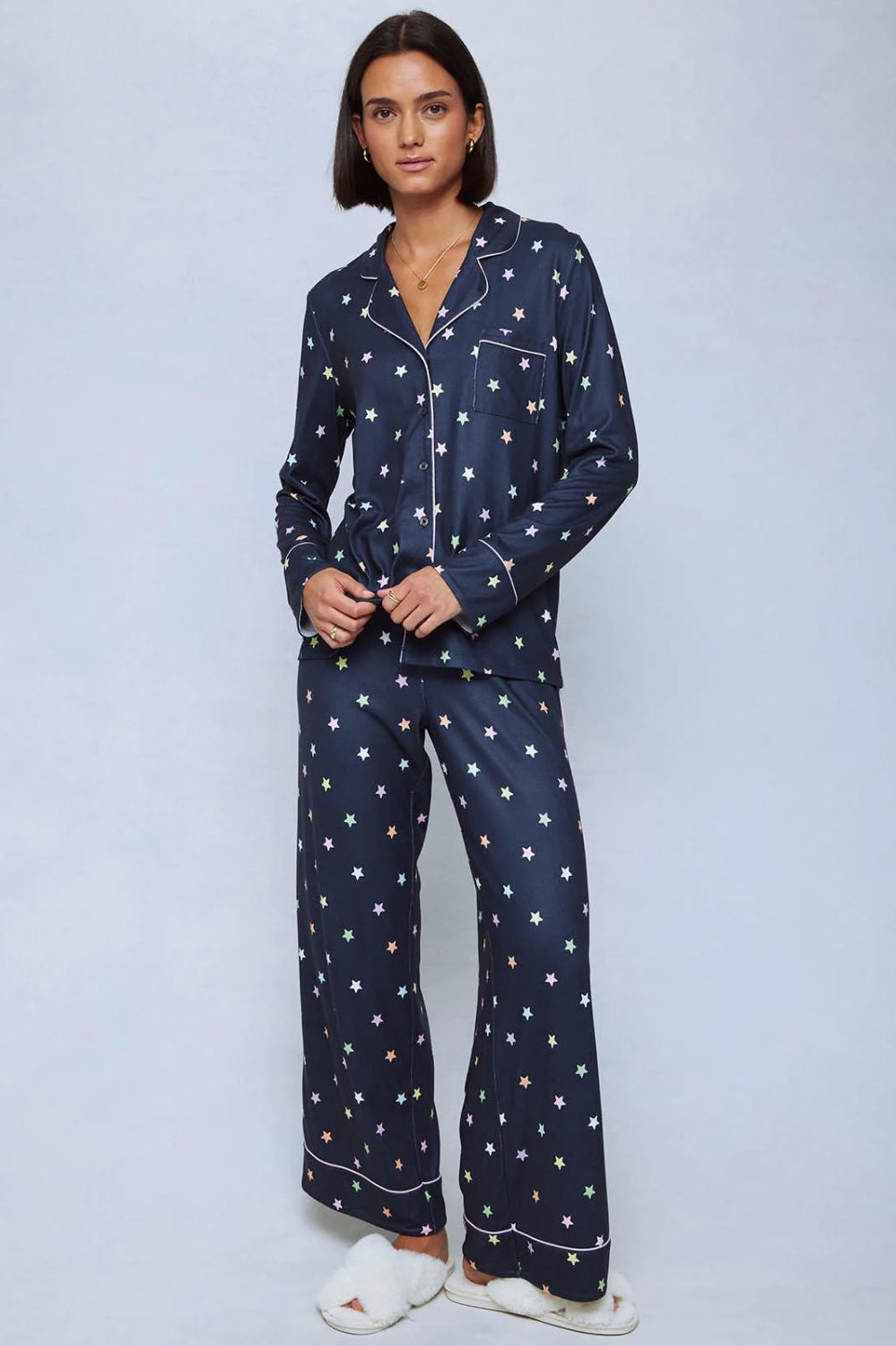 A cozy two-piece sleep set featuring brushed Pillowsoft fabric, a button-front top with contrast piping, and full-length drawstring pants for relaxing in comfort