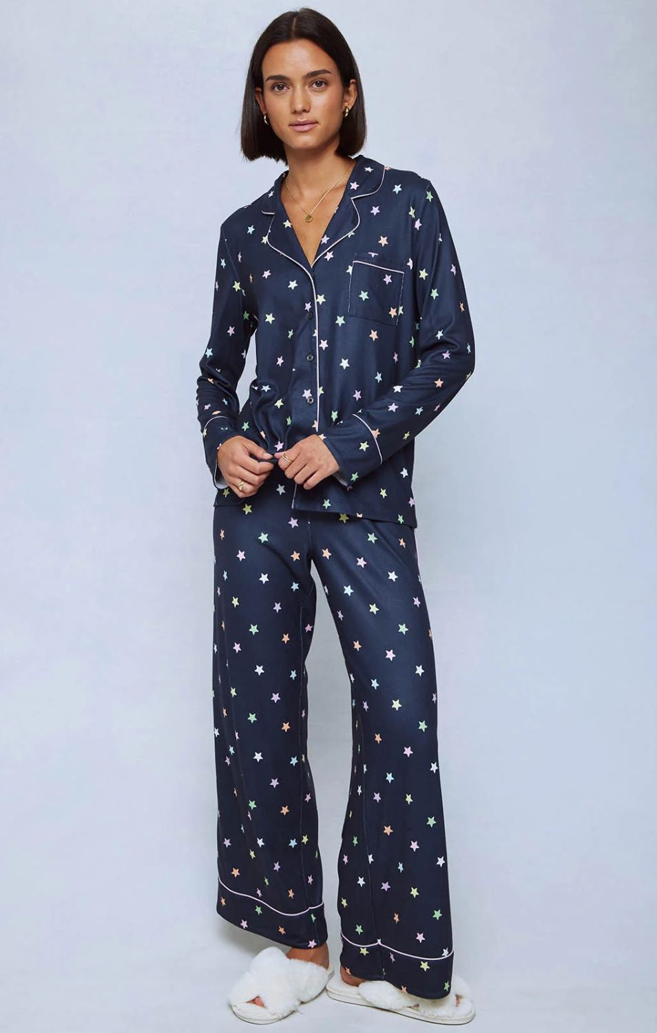 A cozy two-piece sleep set featuring brushed Pillowsoft fabric, a button-front top with contrast piping, and full-length drawstring pants for relaxing in comfort