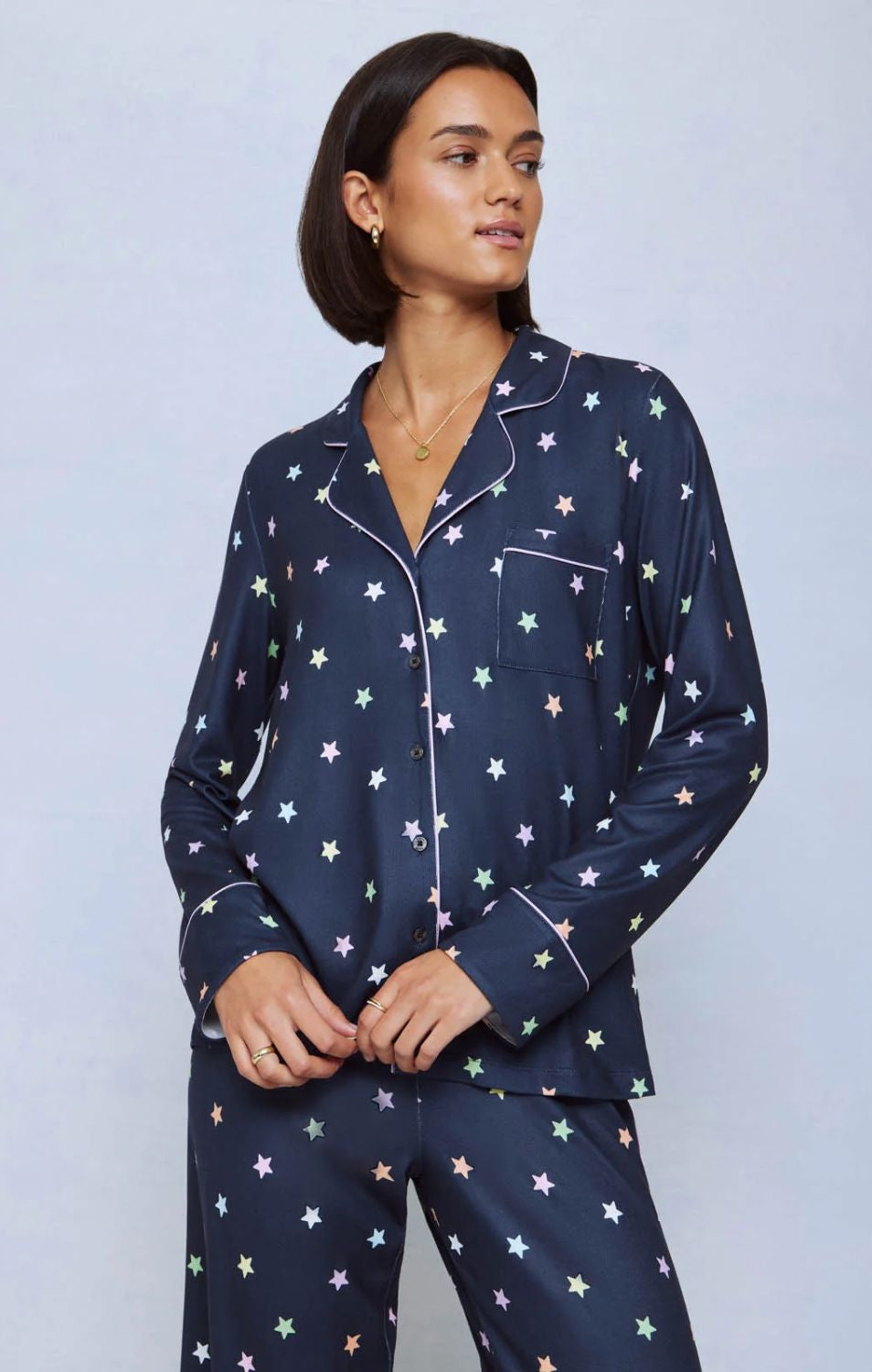 A cozy two-piece sleep set featuring brushed Pillowsoft fabric, a button-front top with contrast piping, and full-length drawstring pants for relaxing in comfort