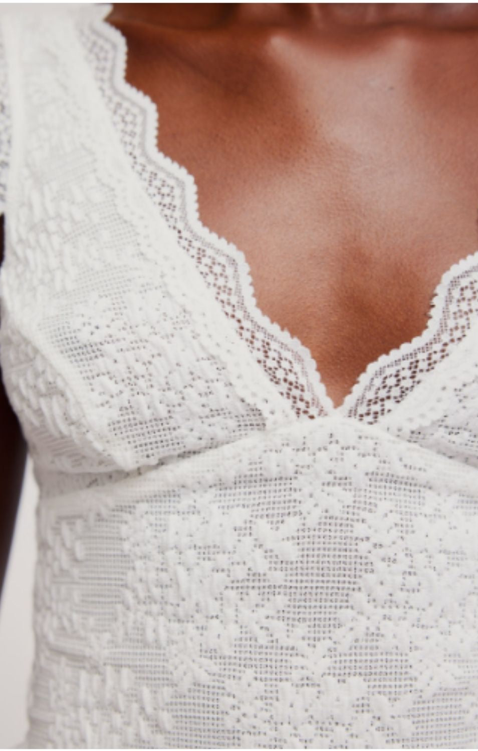 Women's lace tank top featuring a V-neckline, scalloped trim, and feminine open-back detailing