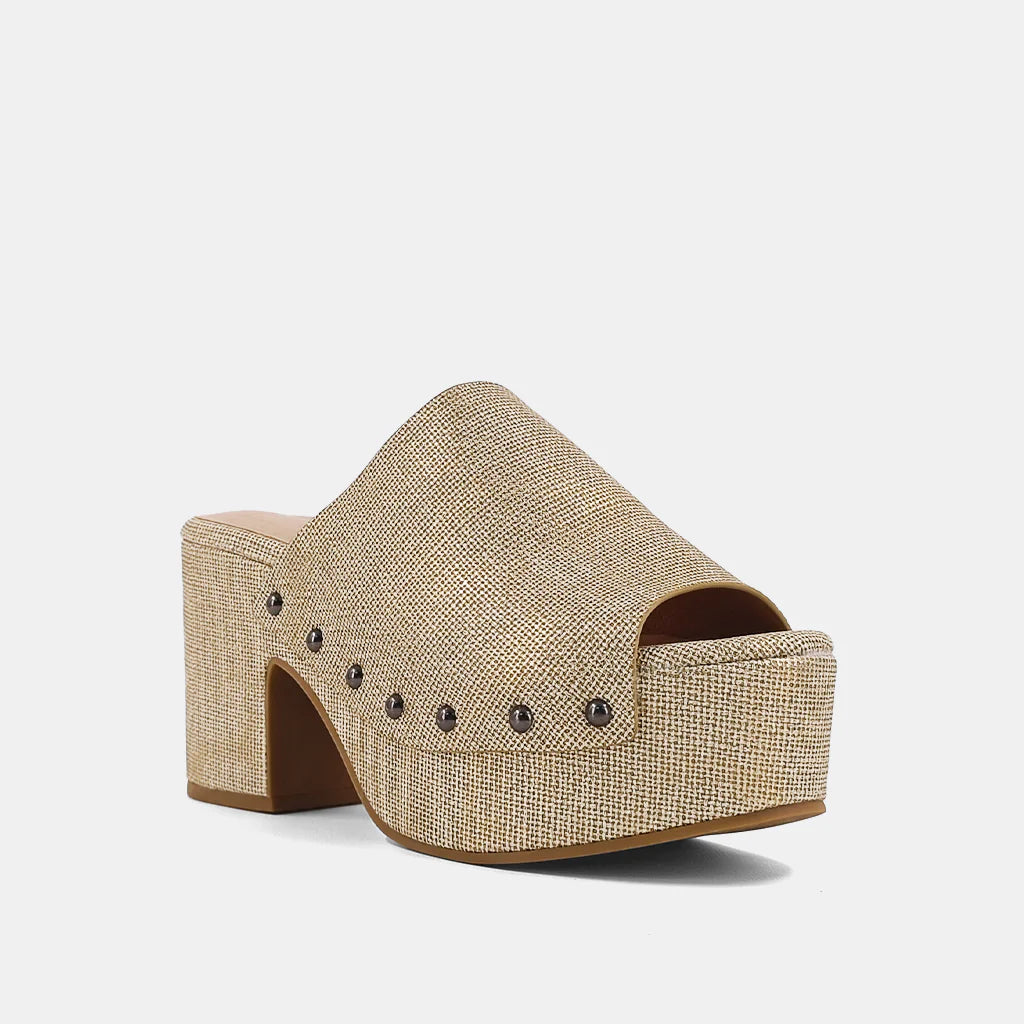 Gina Clog Gold Woven. These shoes are crafted from a soft textured faux leather upper, ensuring you look stylish while staying comfortable all day long. Embellished with charming metallic studs that add a touch of glamour to any outfit, these wedges are perfect to take your look from casual to elegant.