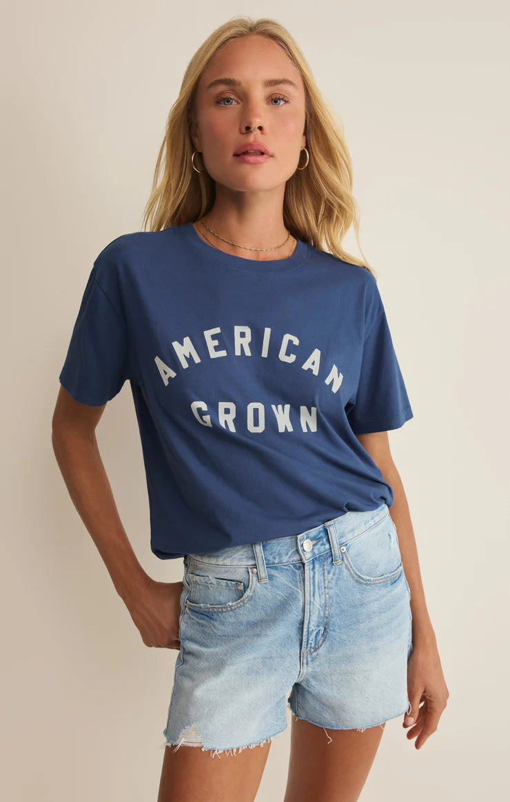 Model wearing a casual graphic tee with “American Grown” text styled with denim shorts.