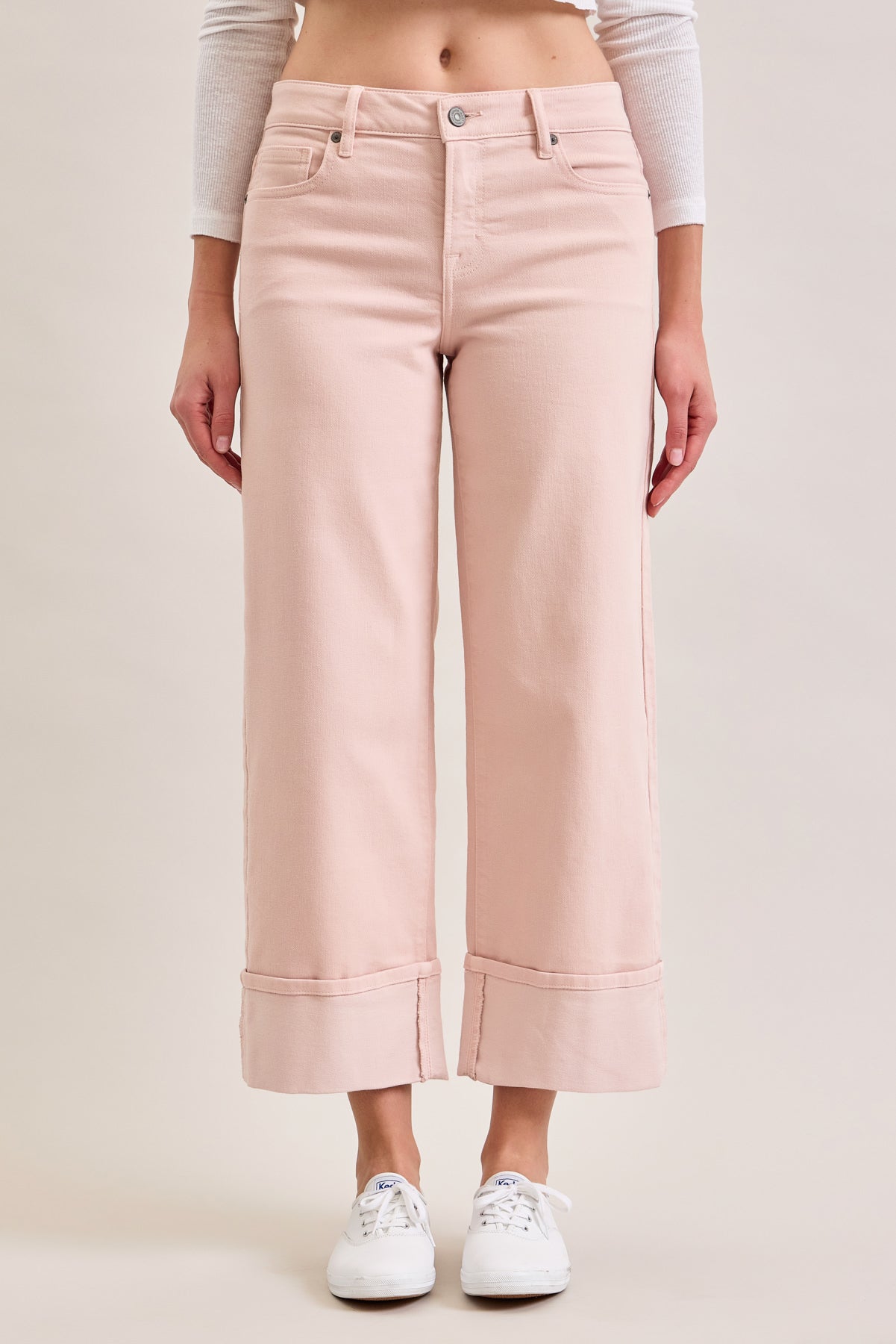 Cropped straight leg jeans with a mid-rise fit and wide cuffed hem worn with sneakers