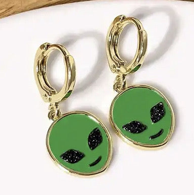Alien Huggie Earrings. These earrings come to our galaxy in peace! Space-out with these adorable. Alien Huggie Earrings. Featuring gold earrings, with a green enamel center, and black stone eyes. These earrings are hypoallergenic and tarnish resistant.