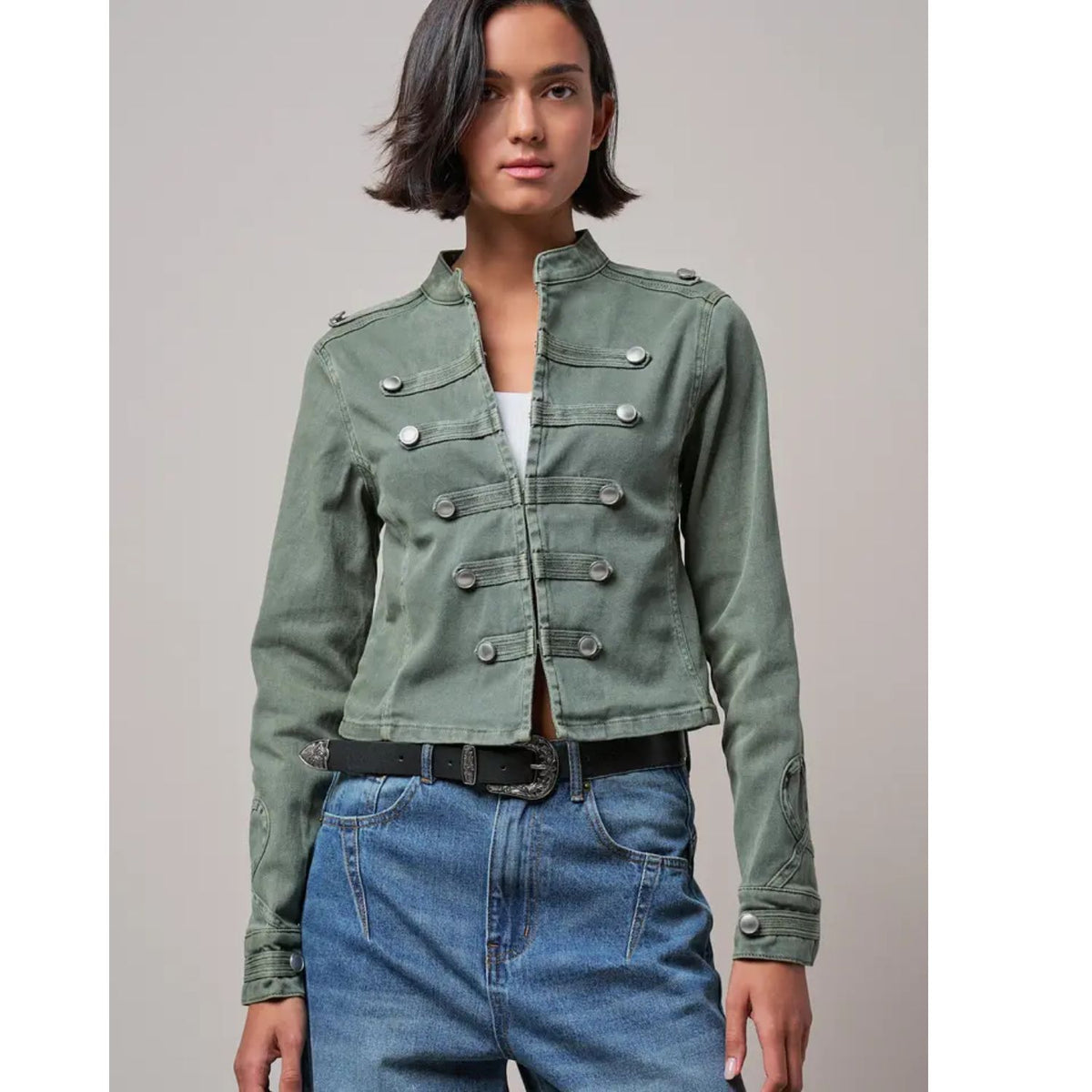 Military-inspired fitted denim jacket with a stand collar, decorative button tabs, and elbow patches