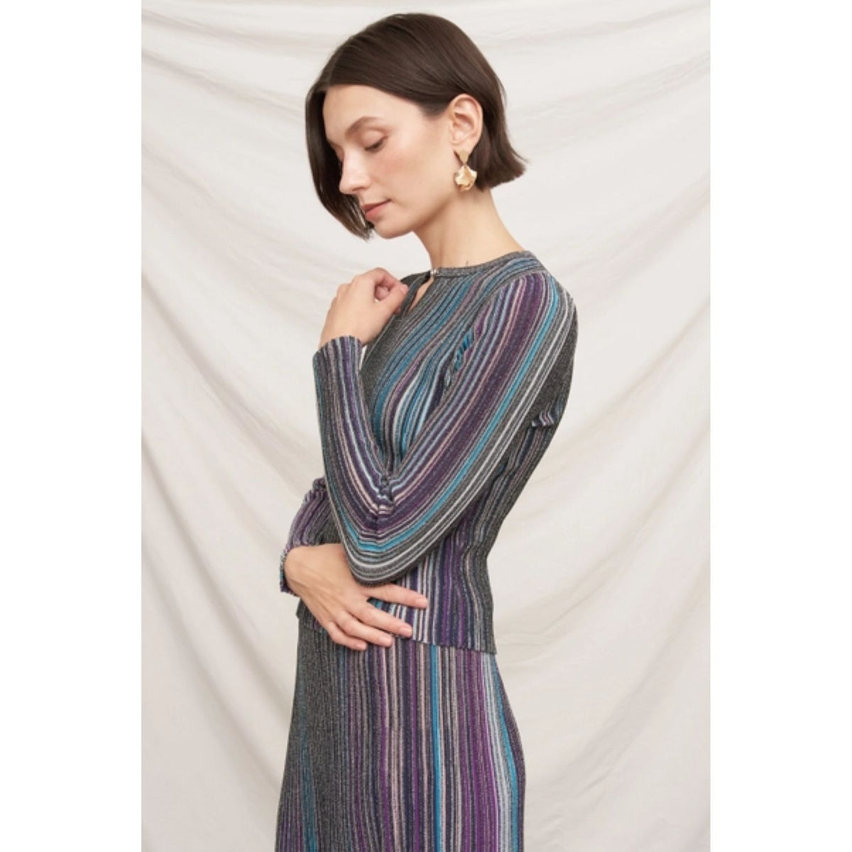 Fitted multicolor striped ribbed knit top with metallic shimmer, split neckline, and long sleeves.