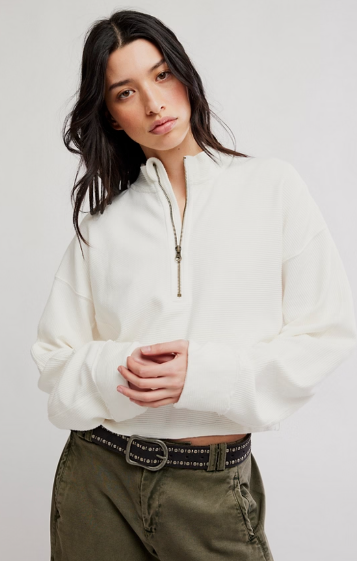 Model wearing a relaxed-fit ribbed half-zip pullover with a stand collar, long sleeves, and a quarter-zip neckline paired with olive green utility pants.