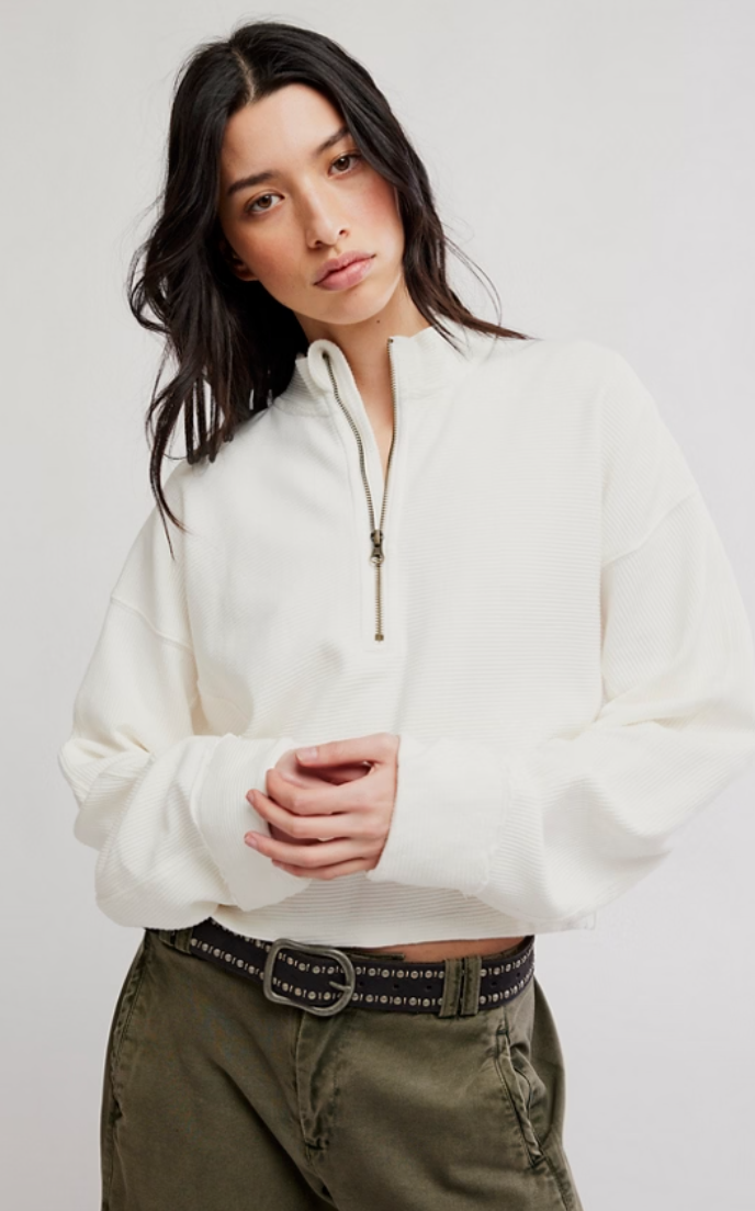 Model wearing a relaxed-fit ribbed half-zip pullover with a stand collar, long sleeves, and a quarter-zip neckline paired with olive green utility pants.