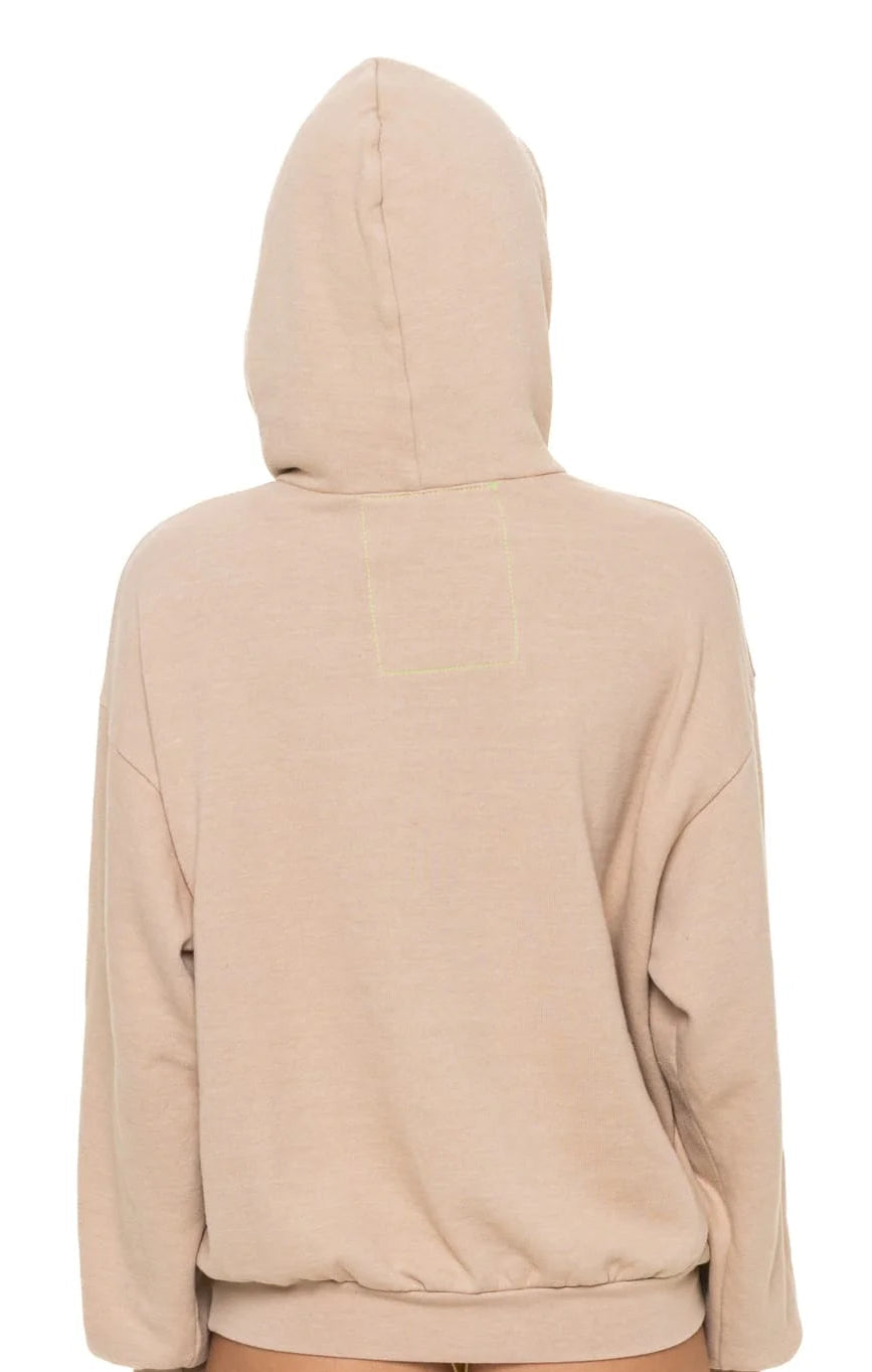 Beige hoodie worn by a person on a white background