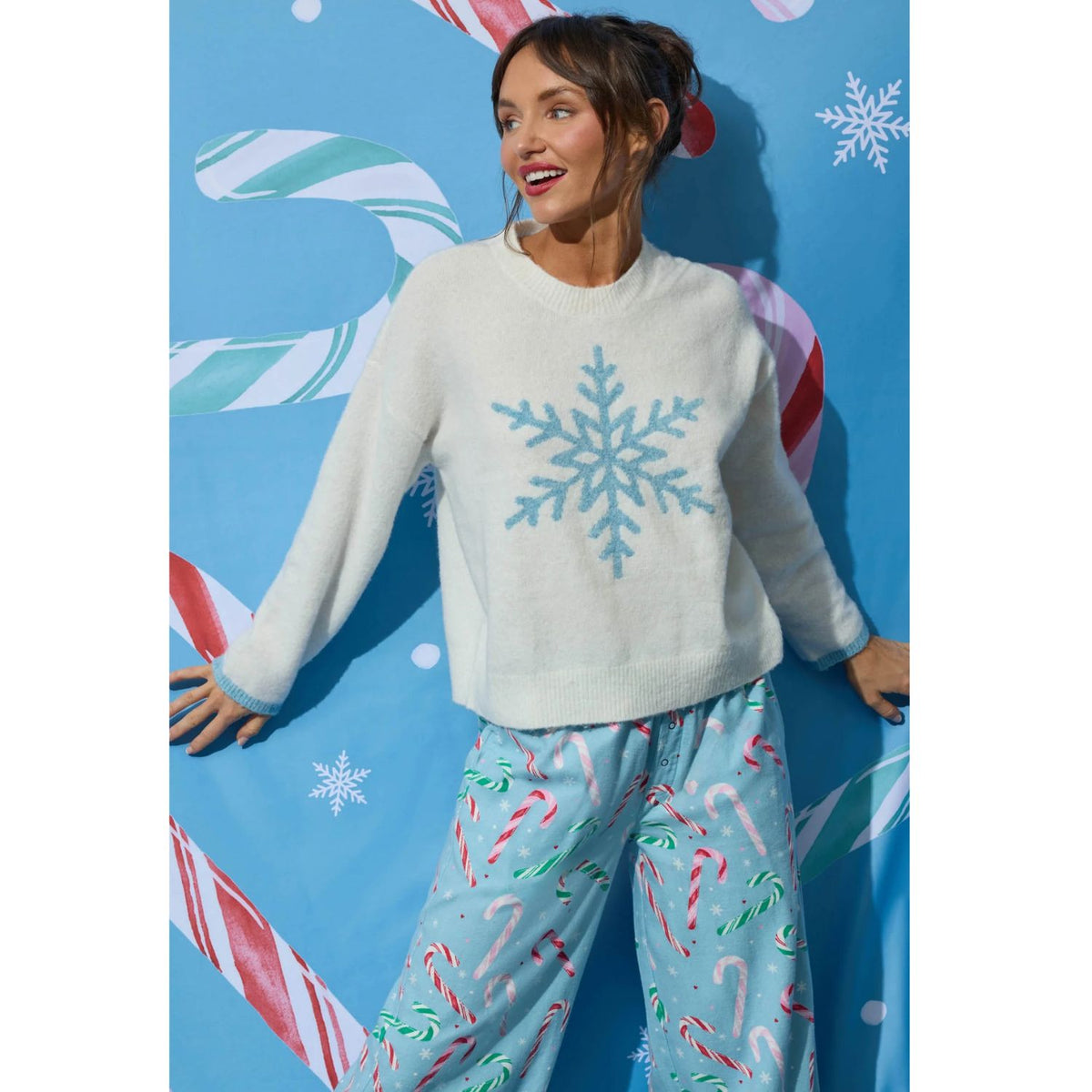 Ivory crewneck sweater with blue snowflake graphic, dropped shoulders, and contrasting blue cuffs