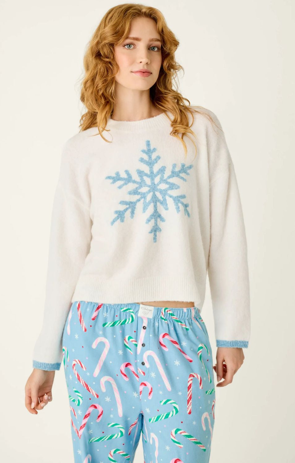 Ivory crewneck sweater with blue snowflake graphic, dropped shoulders, and contrasting blue cuffs