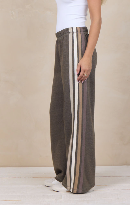 Woman wearing wide-leg heather fleece pants with a varsity side stripe.