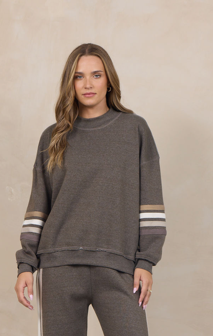 Woman wearing a heather fleece mockneck pullover with dropped shoulders and striped cuffs.