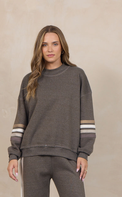 Woman wearing a heather fleece mockneck pullover with dropped shoulders and striped cuffs.