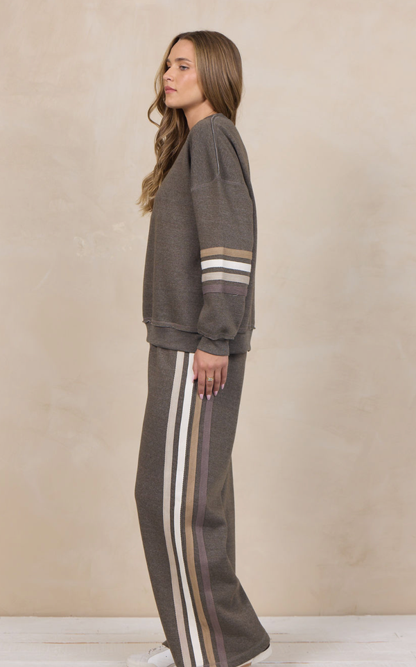 Woman wearing a heather fleece mockneck pullover with dropped shoulders and striped cuffs.