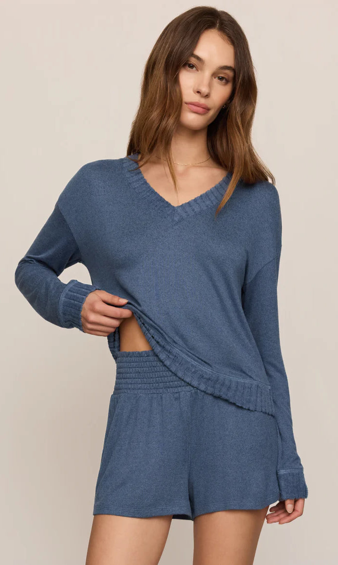 Model wearing a soft V-neck sweater with a relaxed fit and ribbed trim paired with matching lounge shorts.