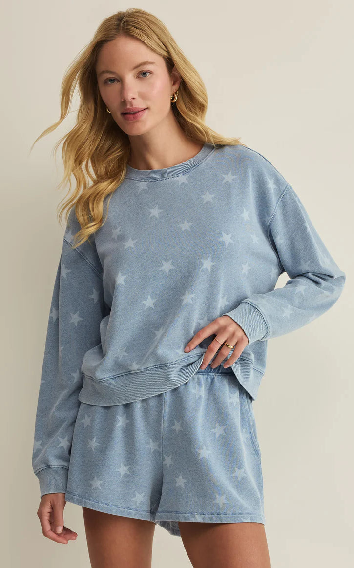 Soft crewneck sweatshirt with allover star print, relaxed fit, and long sleeves, styled with matching lounge shorts and sneakers
