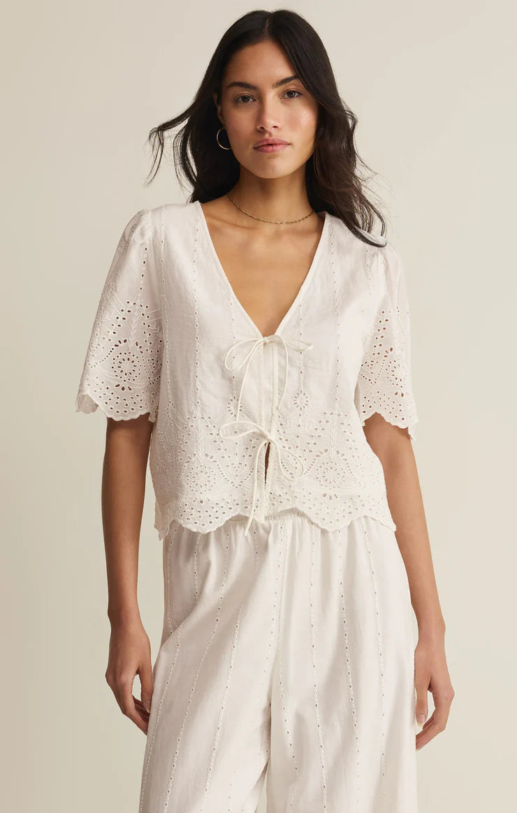 Embroidered short sleeve top with v-neck, tie front, and scalloped hem styled with matching bottoms
