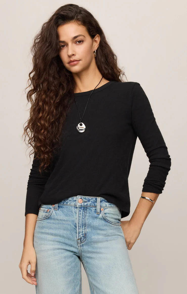 Classic long sleeve crewneck tee with a relaxed fit and soft knit fabric, styled with denim jeans.