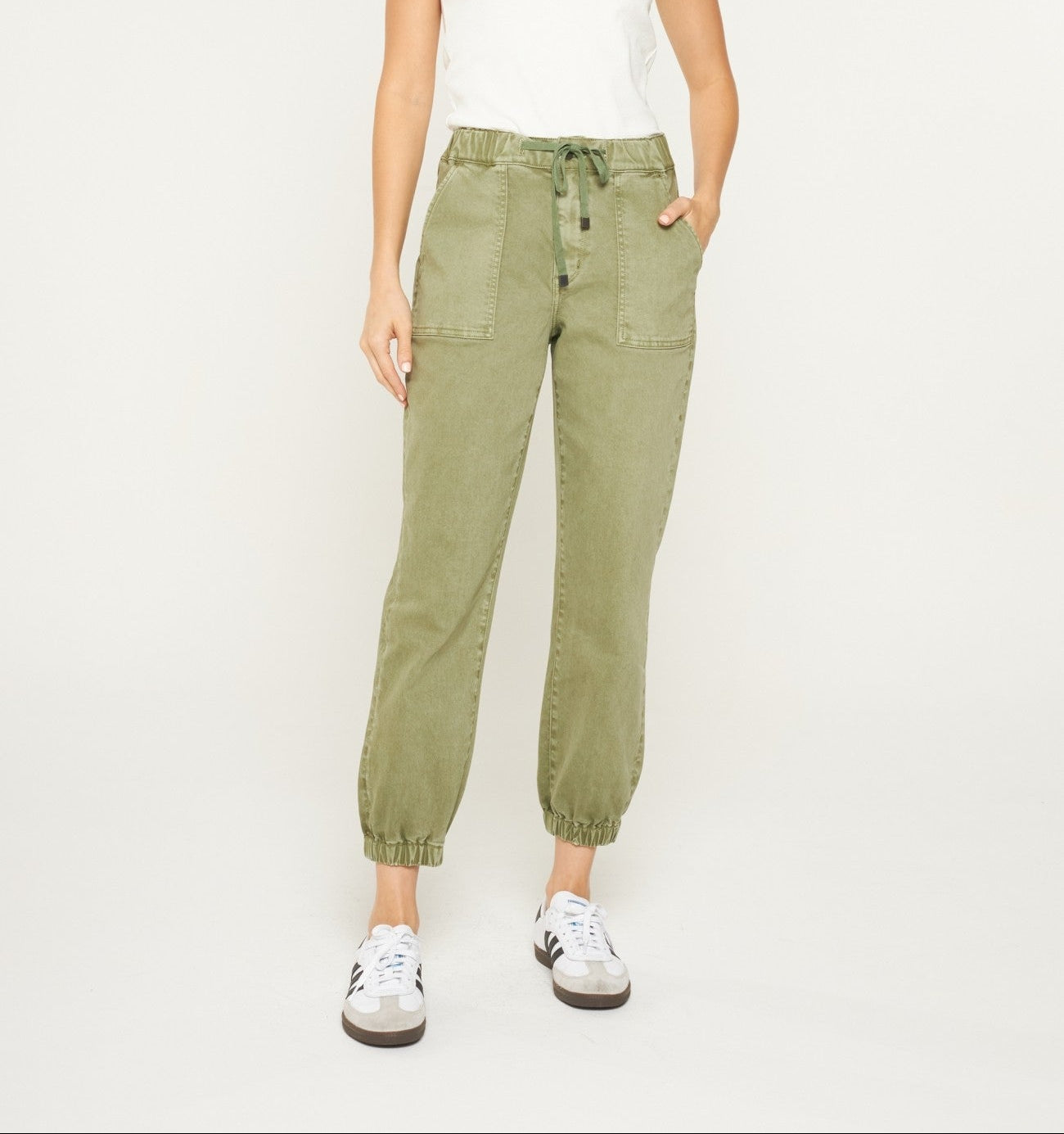 Woman wearing utility jogger pants with a drawstring waist, front patch pockets, and elasticized cuffs.