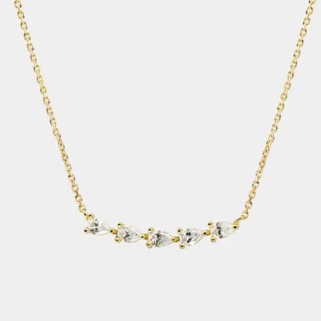 Subtle sparkle, elevated simplicity. This delicate gold chain necklace features a row of marquise-cut stones set in a soft curve for an effortlessly chic look. Feminine and refined, it adds just the right amount of shine whether worn alone or layered with your everyday favorites. A timeless piece that feels special but easy.