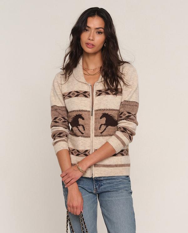 woman wearing jeans with a zip up cardigan with a shawl color and a horse print