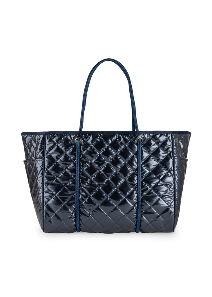 Haute Shore Greyson Navy Shiny Quilted Puffer. This shiny navy puffer tote is the perfect chic everyday bag to use as a carry all for your must haves, with a lightweight design that's perfect for when you're on the go.