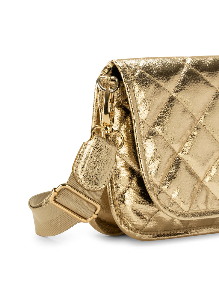 Haute Shore Rae Crossbody Gilt. This crossbody features a quilted design with a flap closure, the perfect size for everyday wear that can be used day or night as a crossbody or a clutch.