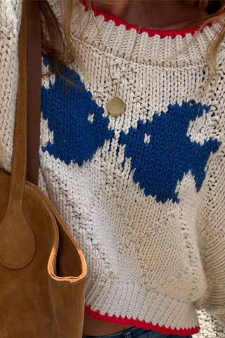 Close-up of the Mccolin Cropped Knit Sweater in Beige with blue pattern and red contrast trim.