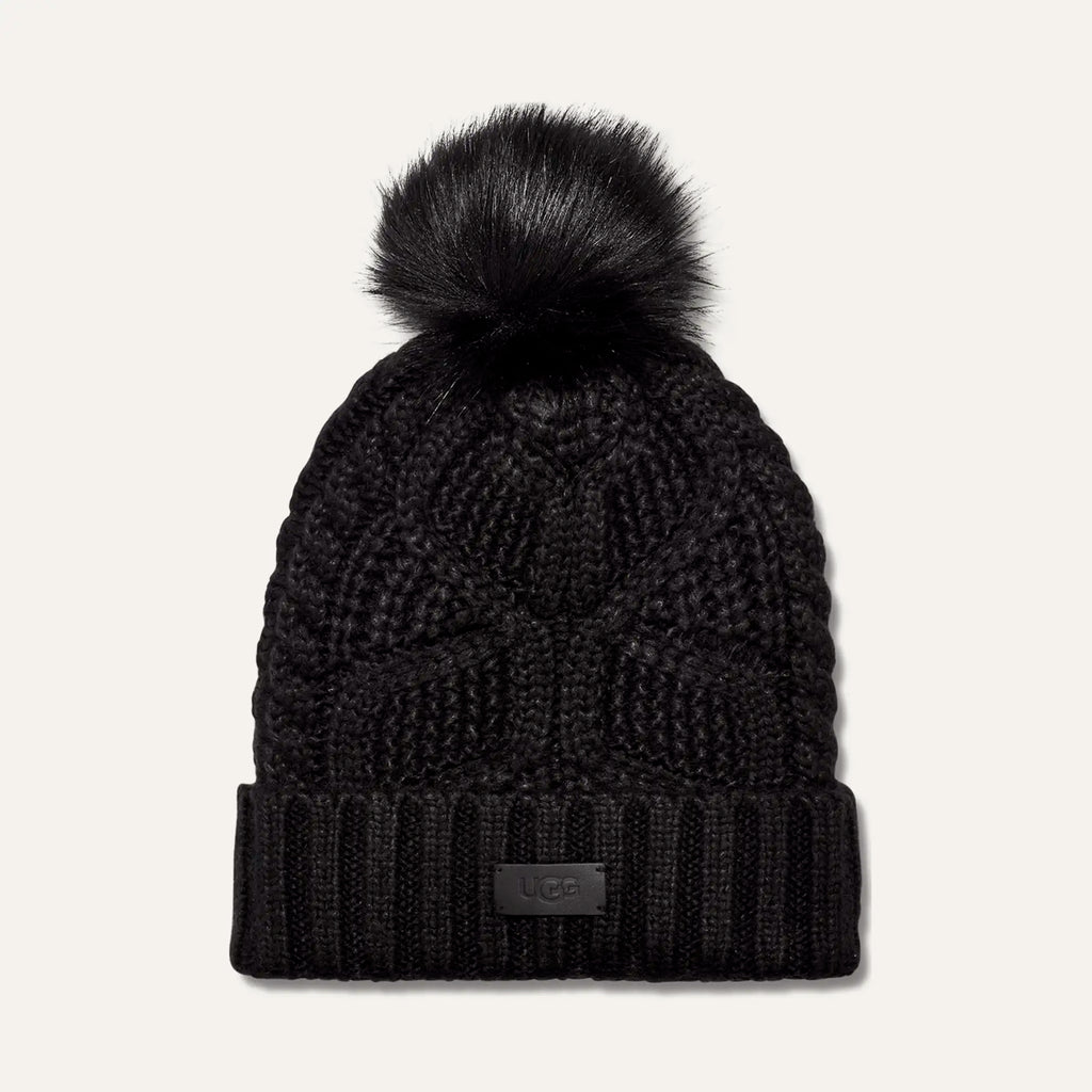 women’s pom beanie, cable knit beanie, winter hat with pom, cozy knit hat, cold weather accessories, faux fur pom hat, ribbed cuff beanie, stylish winter beanie, designer knit hat, soft winter hat, everyday beanie, warm knit accessory, winter fashion essentials, outdoor winter hat, women’s cold weather style