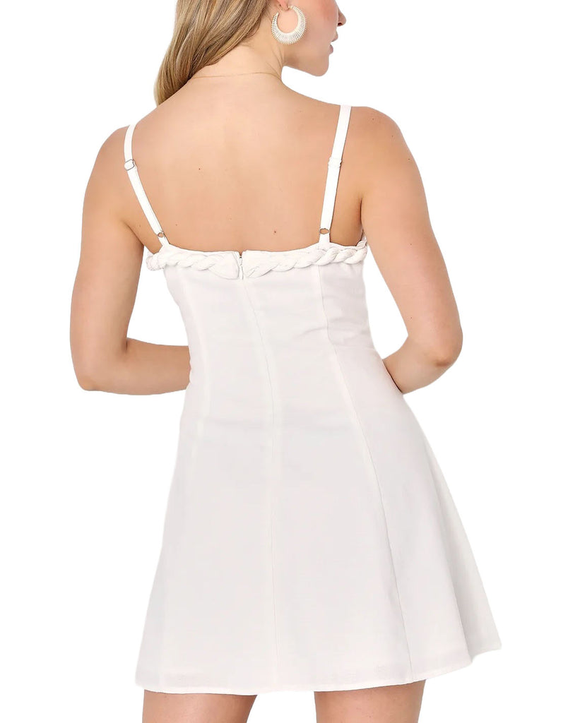 Merida Braided Mini Dress White. This chic summer dress is begging to go out with its linen-cotton blend composition that falls from adjustable spaghetti straps into a straight neckline adorned with a fun braided trim.