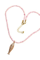 Pink seed bead necklace with an adjustable gold-tone chain and a crystal-embellished fish charm pendant for a fun coastal-inspired style.