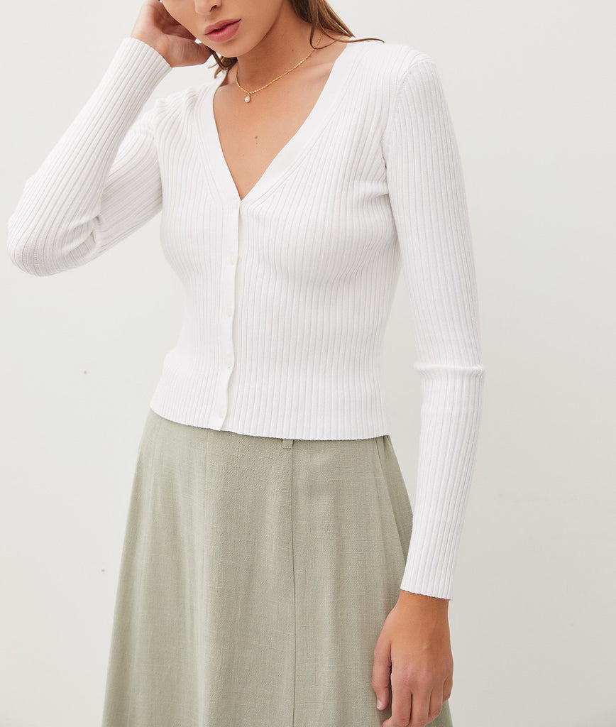 Amina Rib V-Neck Slim Cardi White. This slim fit cardigan features a v-neckline and button down front in a soft ribbed fabric, perfect for wearing open for an extra layer or on its own buttoned closed.
