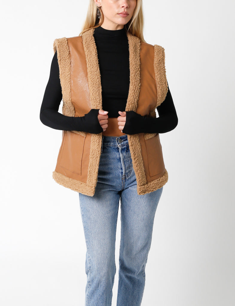 Naomi Leather Fur Lined Vest Light Brown. This faux leather vest features a cozy sherpa fabric lining, the perfect stylish warm layering piece for the fall season.