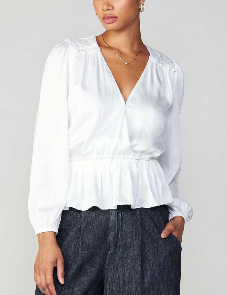 Current Air Peplum Surplus Blouse White. This long sleeve v-neck surplus blouse features a cinched waist with ruffle detail on the shoulder, the perfect everyday top to wear day or night.
