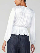 Current Air Peplum Surplus Blouse White. This long sleeve v-neck surplus blouse features a cinched waist with ruffle detail on the shoulder, the perfect everyday top to wear day or night.