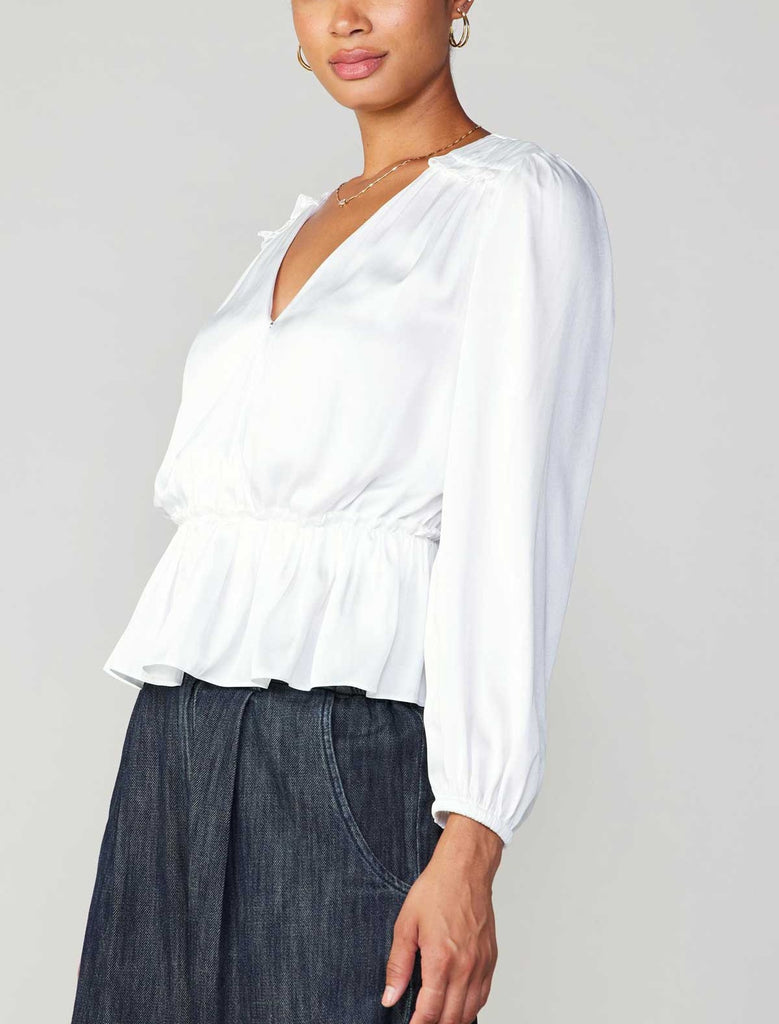 Current Air Peplum Surplus Blouse White. This long sleeve v-neck surplus blouse features a cinched waist with ruffle detail on the shoulder, the perfect everyday top to wear day or night.