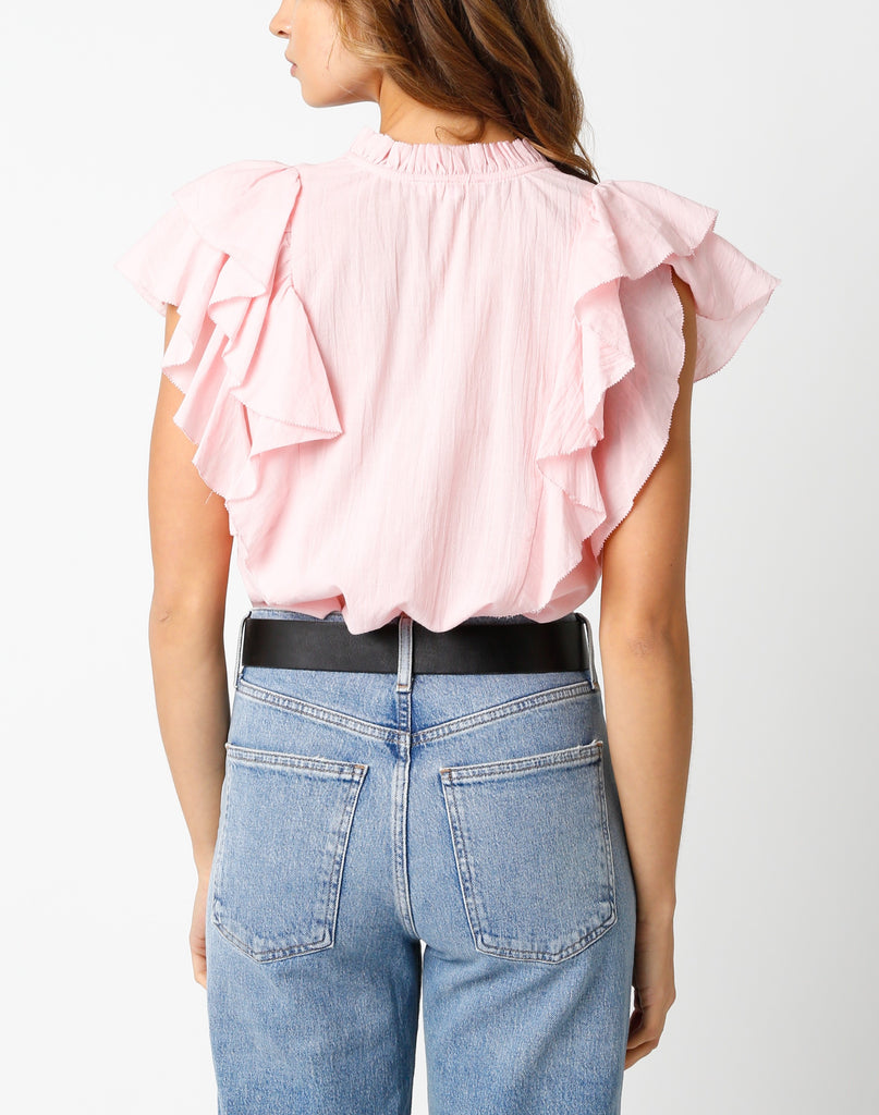 Jayla Ruffle Sleeve Blouse Light Pink. This ruffle sleeve blouse features a v-neckline with tassel bottom front ties, the perfect top to throw on with your favorite jeans for an easy put together look.