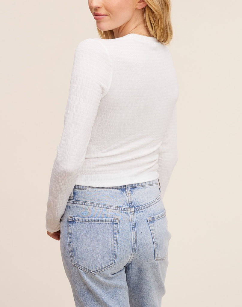 Sabrina Ruched Top White. This fitted long sleeve top features ruching detail throughout for the perfect update to your basic white tee, pair it with your fav jeans for a casual cute look.