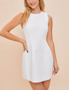 Tamara High Neck Mini Dress White. This adorable mini dress features a high neck and a-line fit with a zip close back, so easy to dress up with heels or down with sneakers and a denim jacket.